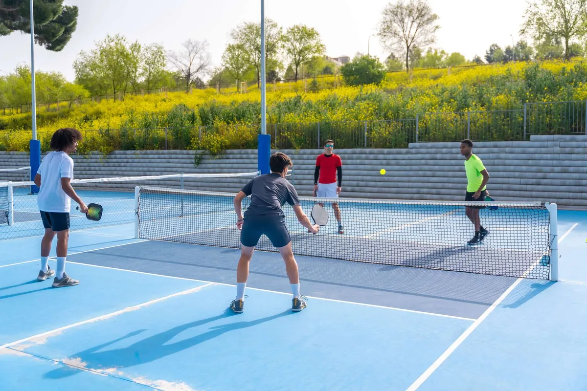 Four friends playing pickleball in athletic clothing.