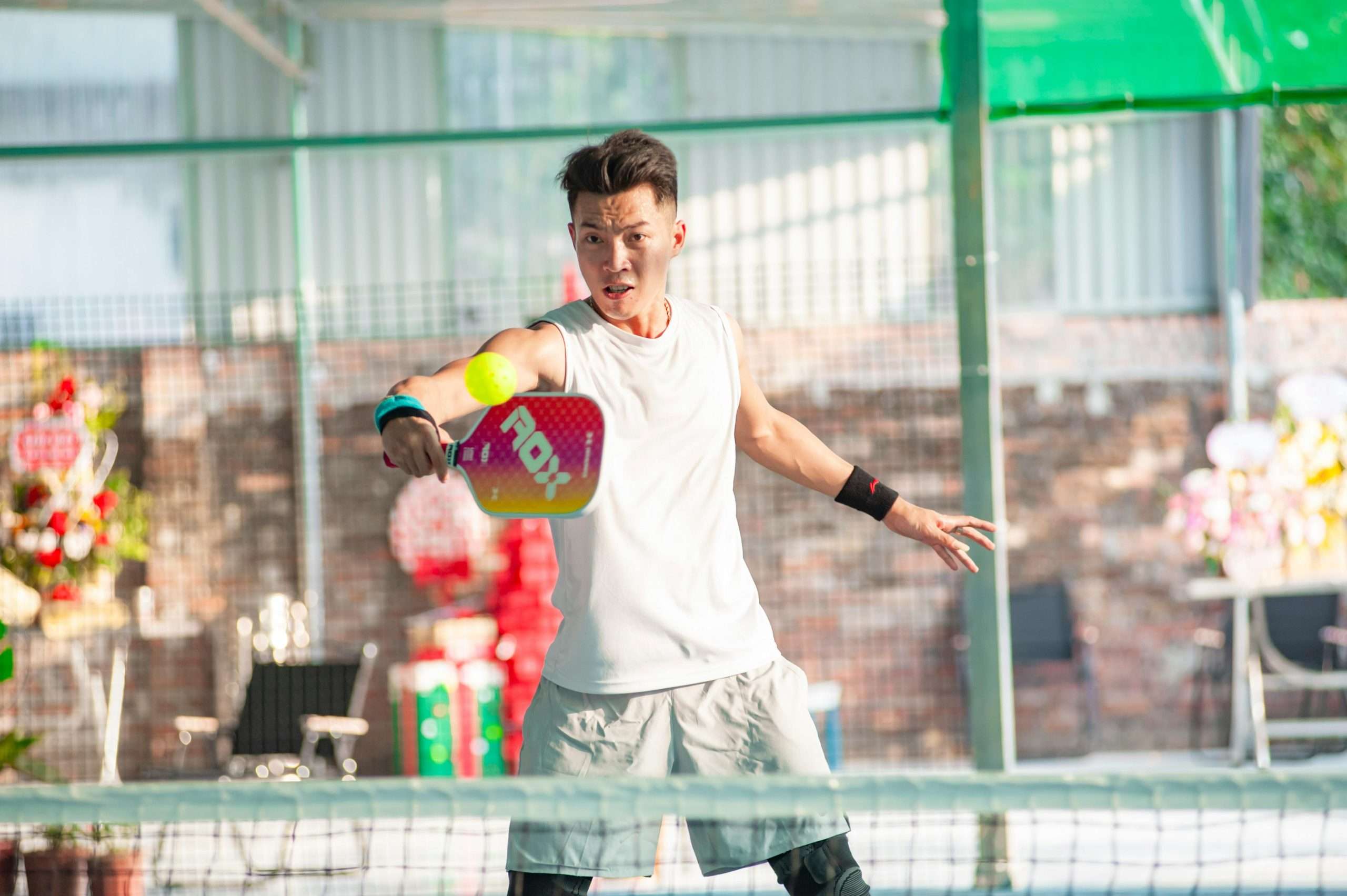 A young woman on a pickleball court, dressed in athletic attire and ready to play.