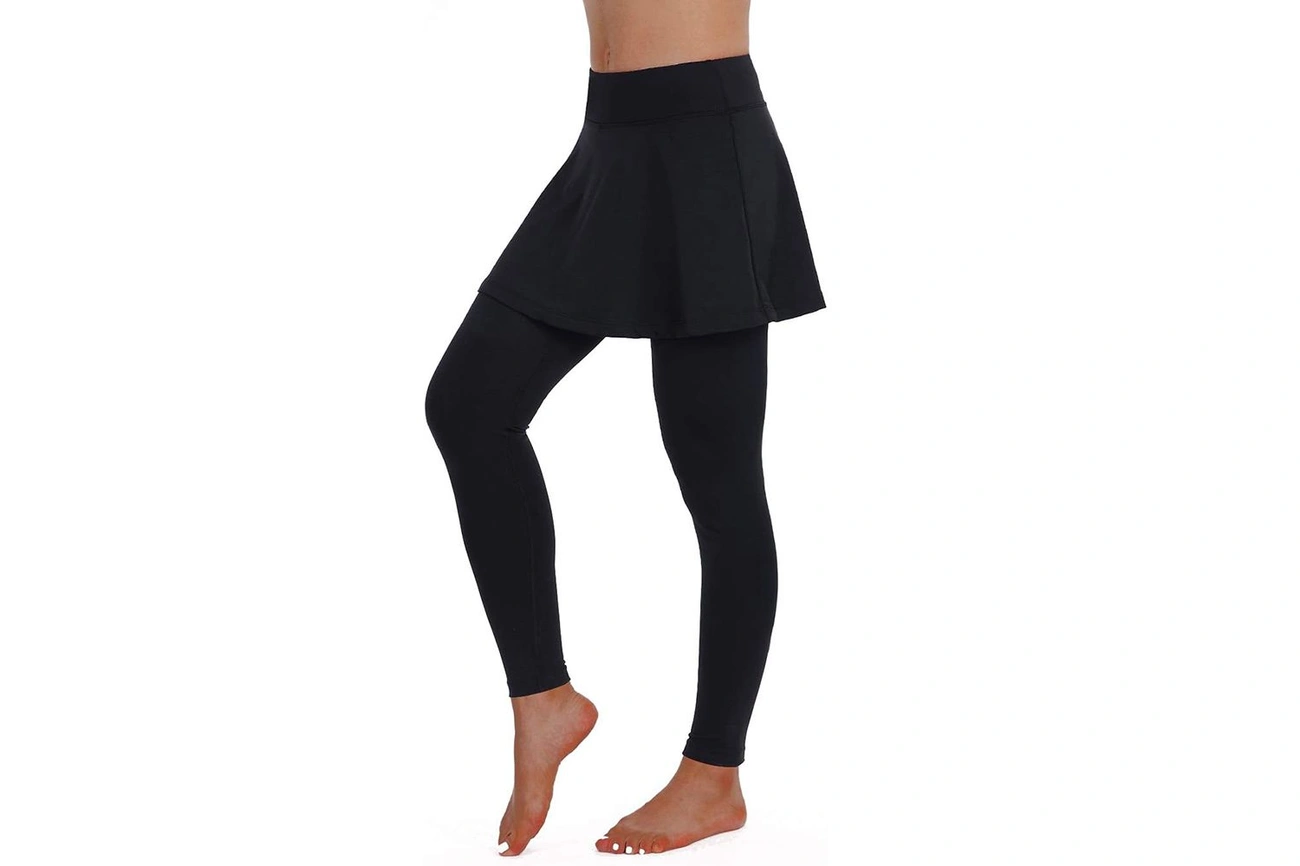 A black sports skirt is worn over full-length black leggings.