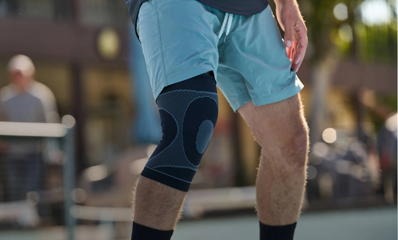 A player wears a knee sleeve with court shorts.