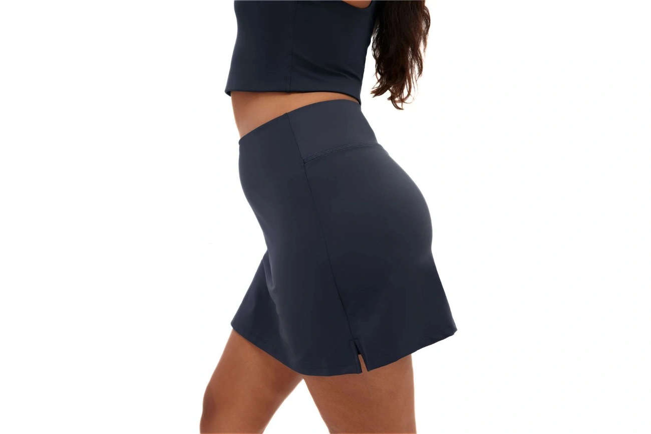 A player wears a dark navy skirt and a matching crop top.